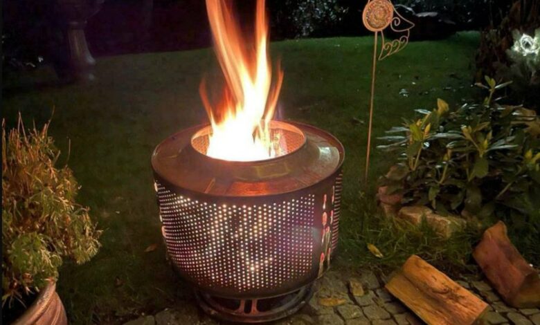 Selbstgebauter Feuerkorb aus einer Waschmaschinentrommel auf Steinfläche