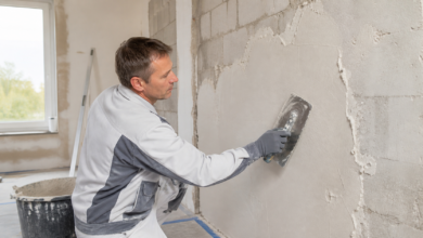 Gipsputz wird mit einer Glättkelle auf eine Innenwand aufgetragen