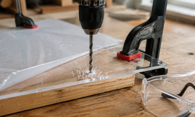 Transparente Kunststoffplatte wird festgespannt auf einer Holzunterlage sauber gebohrt